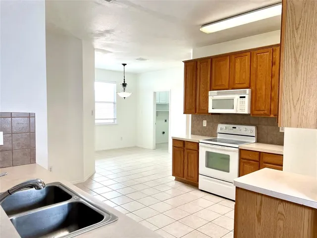 a kitchen with stainless steel appliances a stove a sink and a microwave