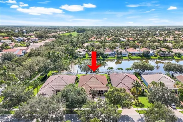 an aerial view of residential houses with outdoor space and trees