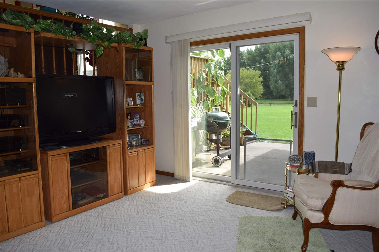 10937 Barron Road Chana, IL 61015 - Photo 15 of 23 a living room with furniture a flat screen tv and a floor to ceiling window