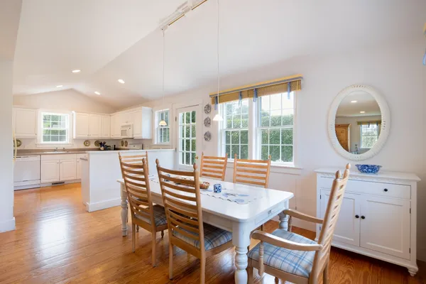 a view of a dining room with furniture a rug and wooden floor