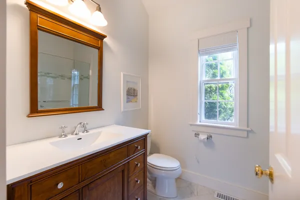 a bathroom with a sink vanity granite and toilet