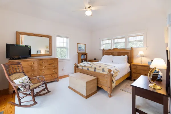 a bedroom with a bed a dresser and a window