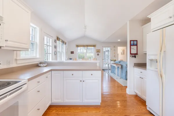a large kitchen with cabinets and wooden floor