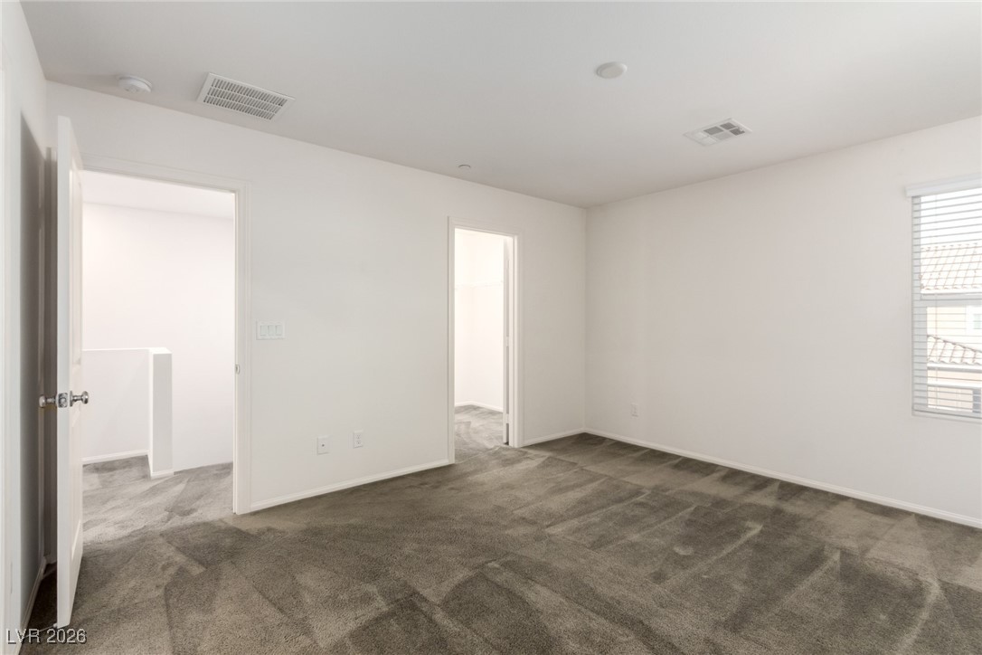 2862 Turnstone Ridge Street Henderson, NV 89044 - Photo 16 of 30 Empty room with dark colored carpet and baseboards