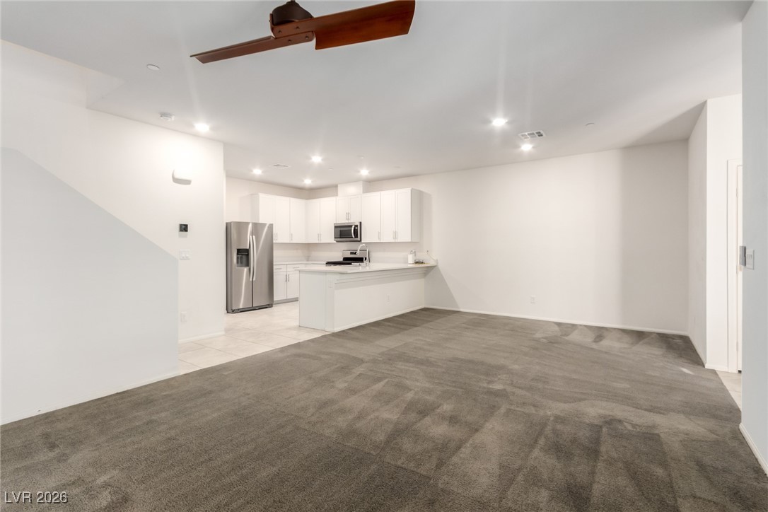 2862 Turnstone Ridge Street Henderson, NV 89044 - Photo 3 of 30 Unfurnished living room featuring ceiling fan, light colored carpet, and recessed lighting