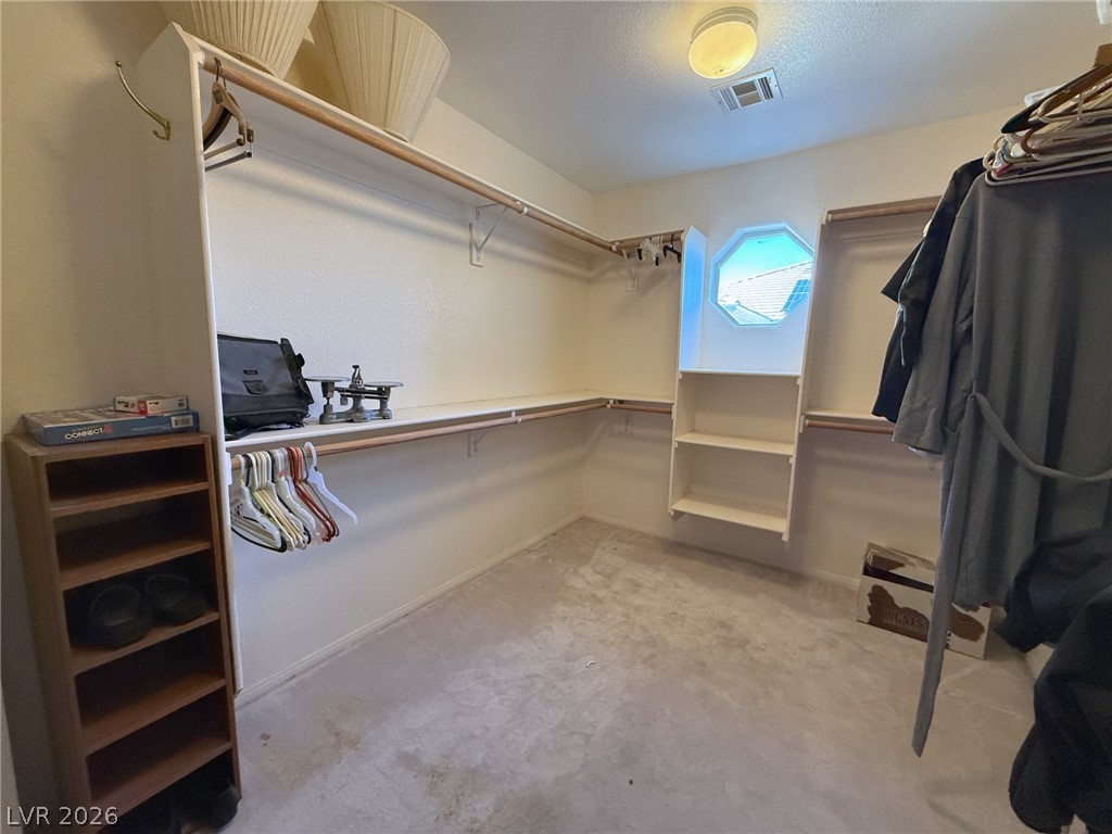 5470 Grain Mill Road Pahrump, NV 89061 - Photo 25 of 80 Ample built-in shelving and hanging rods organize this walk-in closet under a unique octagonal window.