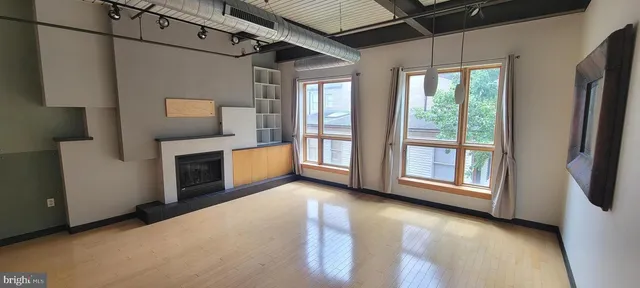 a view of a kitchen with furniture a fireplace and windows