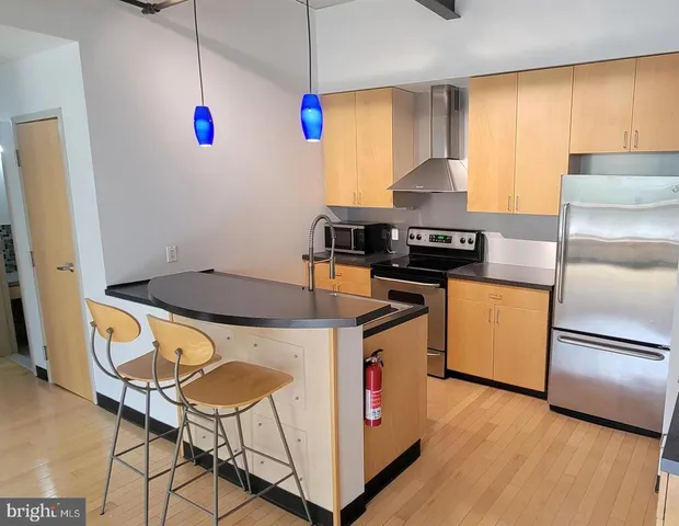 a kitchen with granite countertop a stove a sink and a refrigerator
