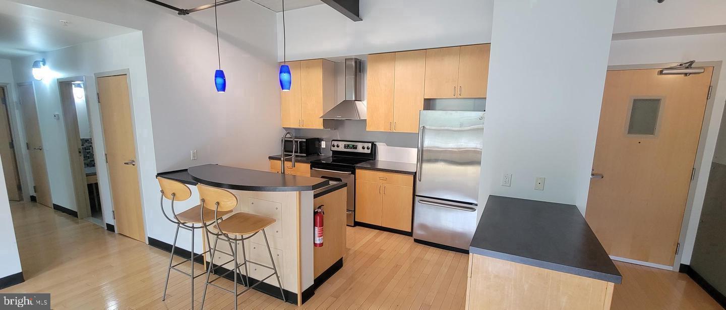 75 Maple Street, Unit 202 Conshohocken, PA 19428 - Photo 6 of 36 a kitchen with stainless steel appliances granite countertop a stove a refrigerator and a microwave