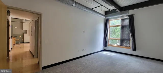 a view of a hallway with wooden floor and a living room