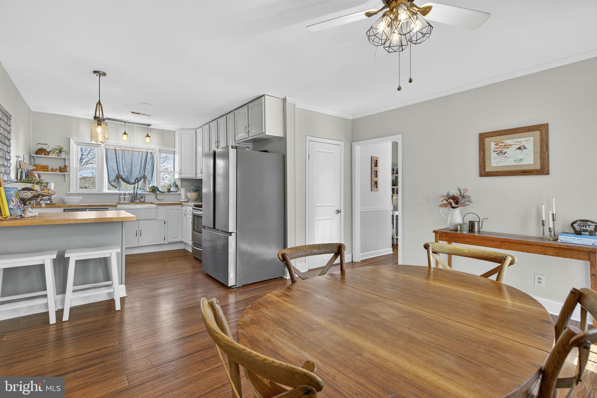 18321 Carrico Mills Road Stevensburg, VA 22741 - Photo 20 of 62 a kitchen with stainless steel appliances refrigerator dining table and chairs