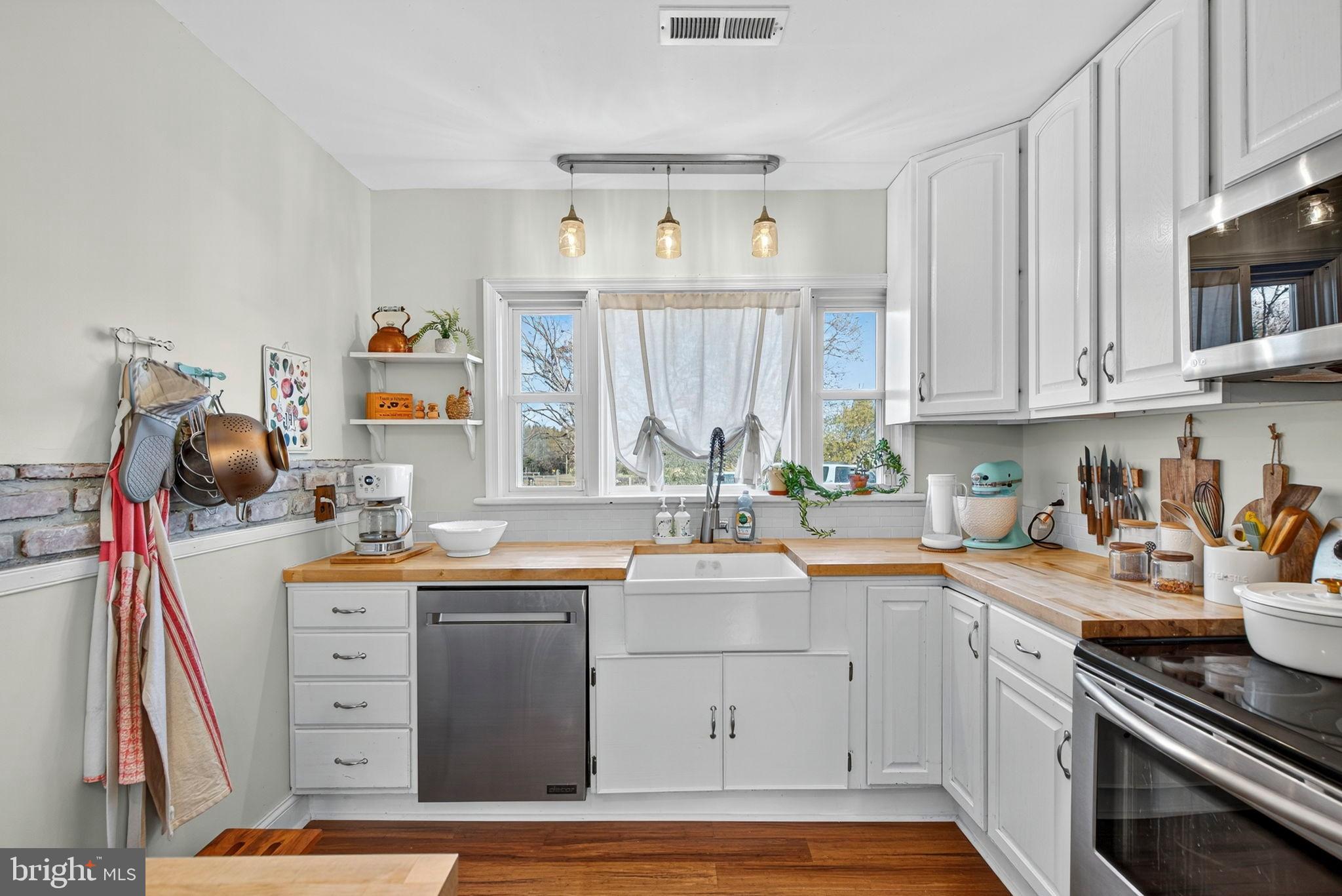 18321 Carrico Mills Road Stevensburg, VA 22741 - Photo 23 of 62 a kitchen with stainless steel appliances a sink stove and cabinets
