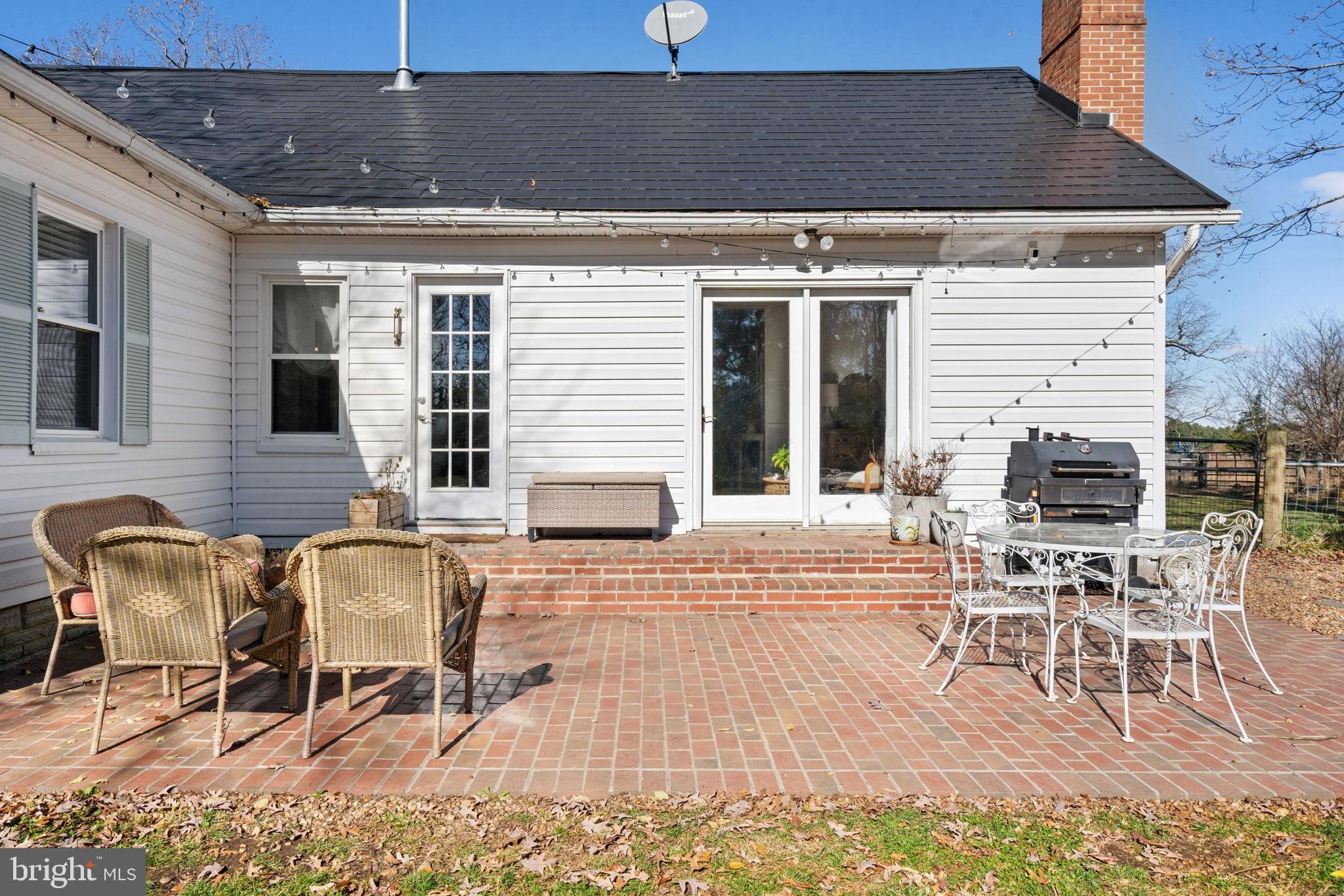18321 Carrico Mills Road Stevensburg, VA 22741 - Photo 42 of 62 a patio with a table and chairs