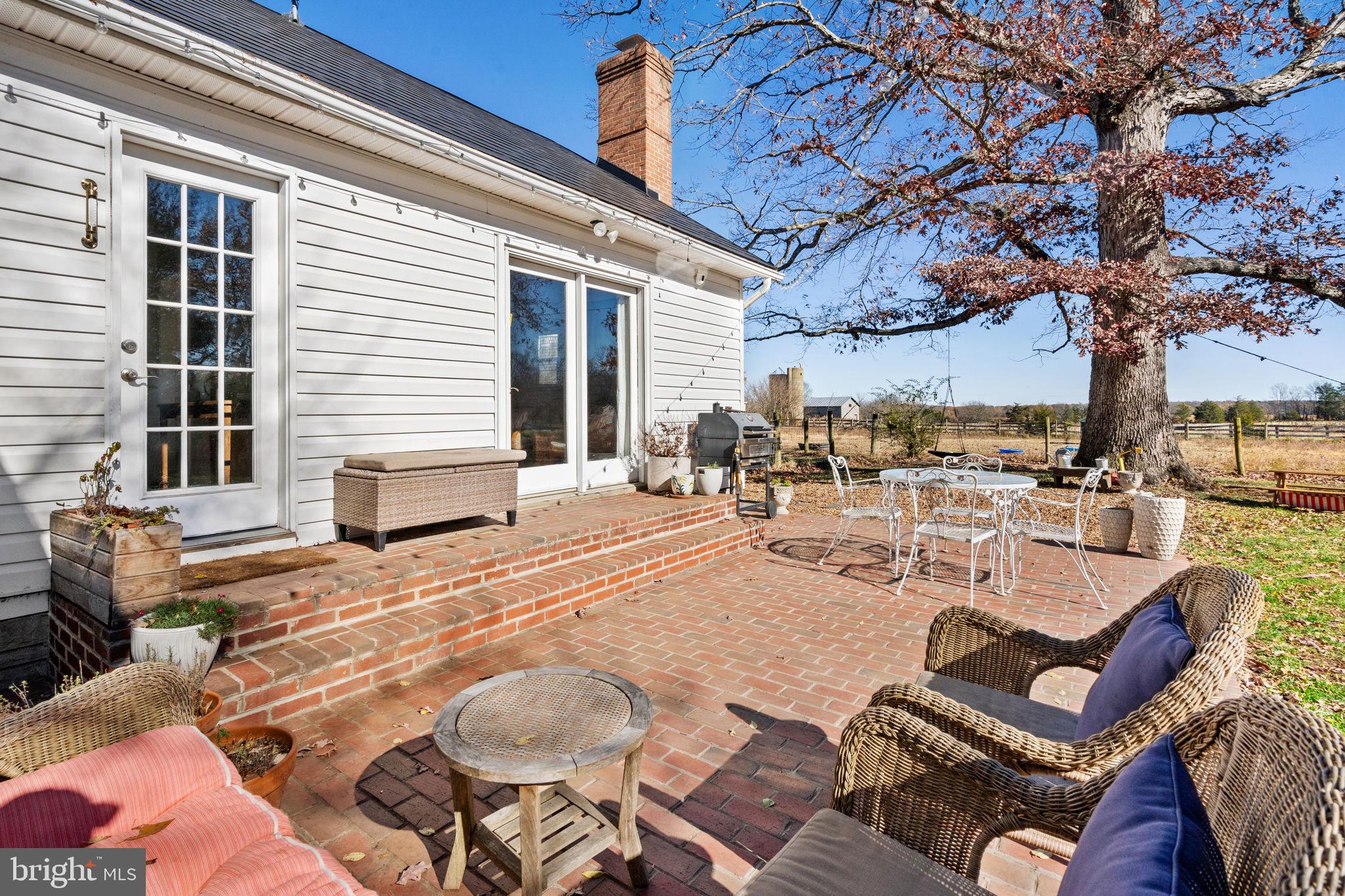 18321 Carrico Mills Road Stevensburg, VA 22741 - Photo 43 of 62 a view of a patio with couches chairs and a fire pit