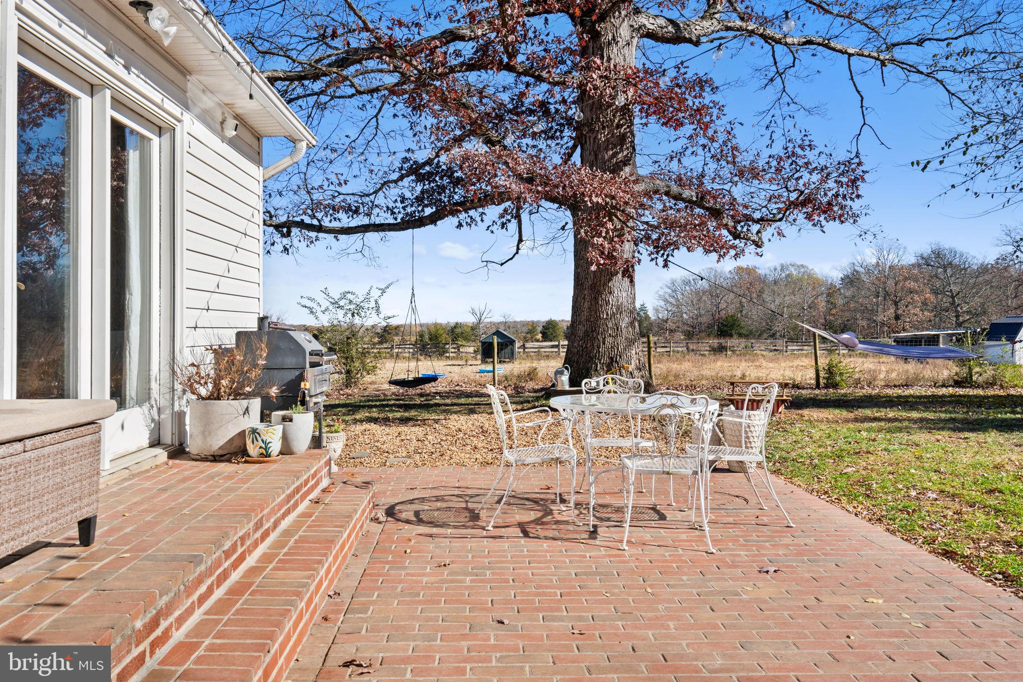 18321 Carrico Mills Road Stevensburg, VA 22741 - Photo 44 of 62 a view of a patio with dining table and chairs with wooden floor and fence