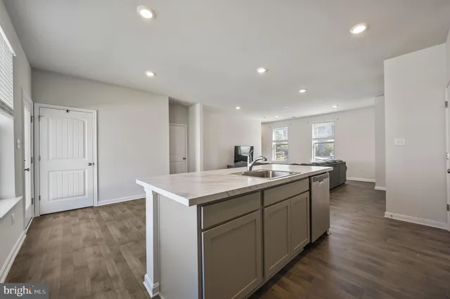 a kitchen with a sink and wooden floor