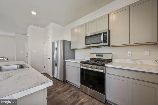 a kitchen with stainless steel appliances granite countertop a stove a refrigerator and a microwave