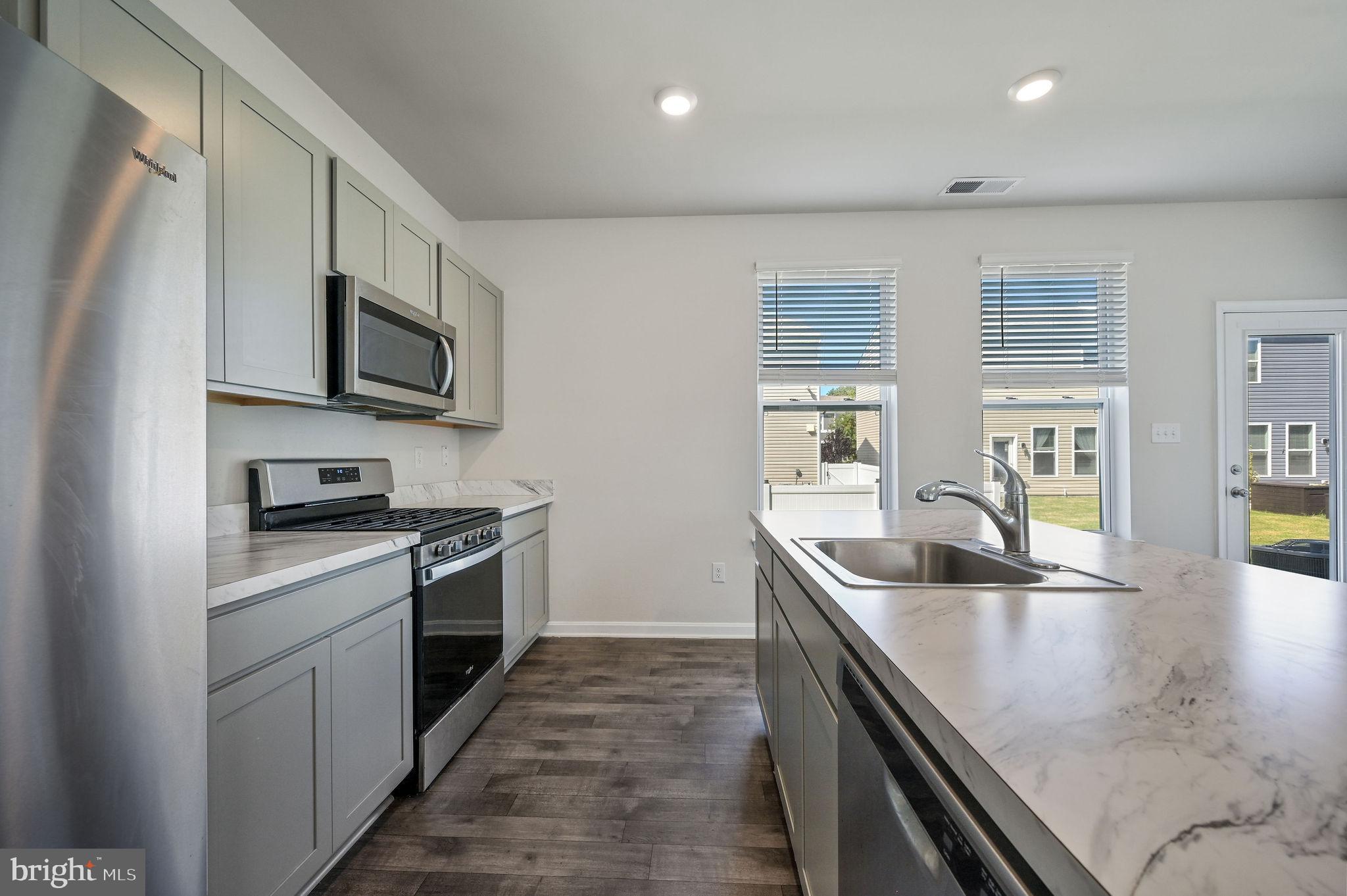 49 Citrus Drive Camden Wyoming, DE 19934 - Photo 17 of 27 a kitchen with stainless steel appliances granite countertop a sink a stove and a refrigerator