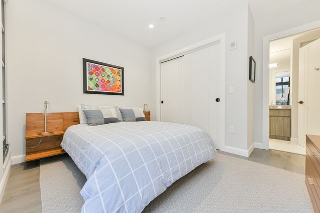 a bedroom with a bed and a painting on the wall