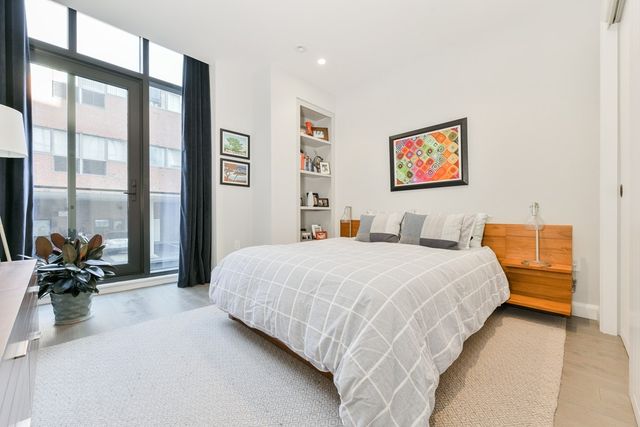 a bedroom with bed and large windows