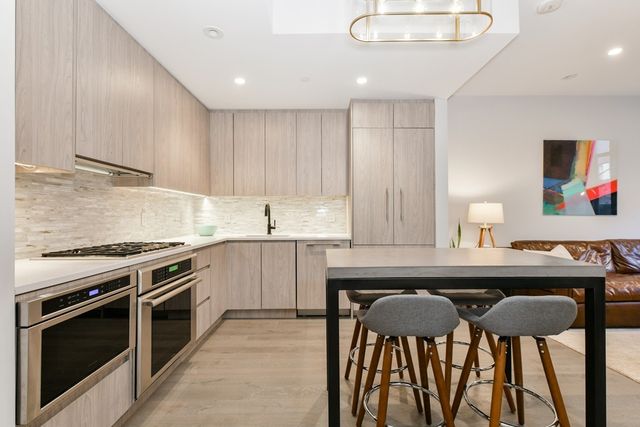 a kitchen with a table chairs sink and cabinets