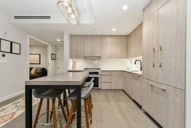a kitchen with a table chairs refrigerator and cabinets