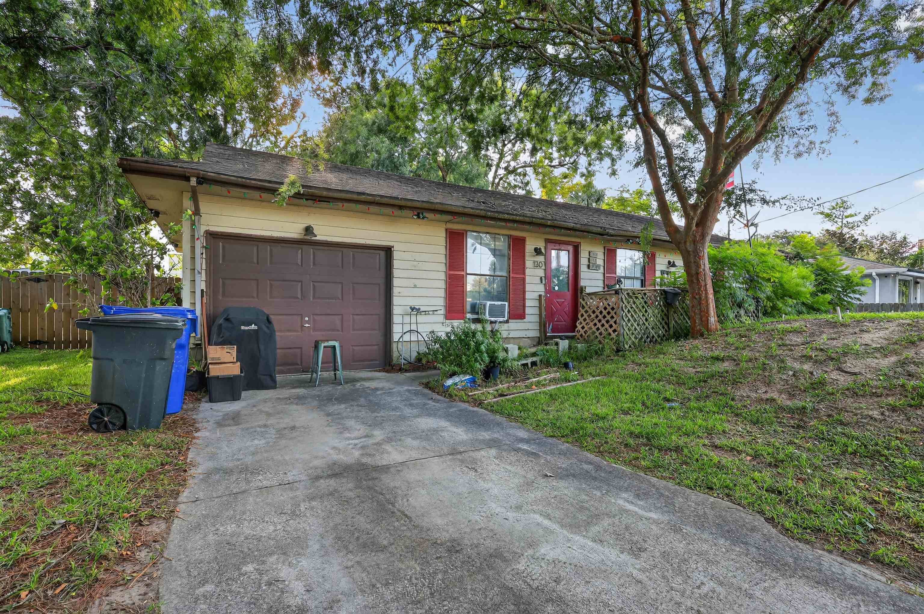 a view of a house with a yard and a large tree
