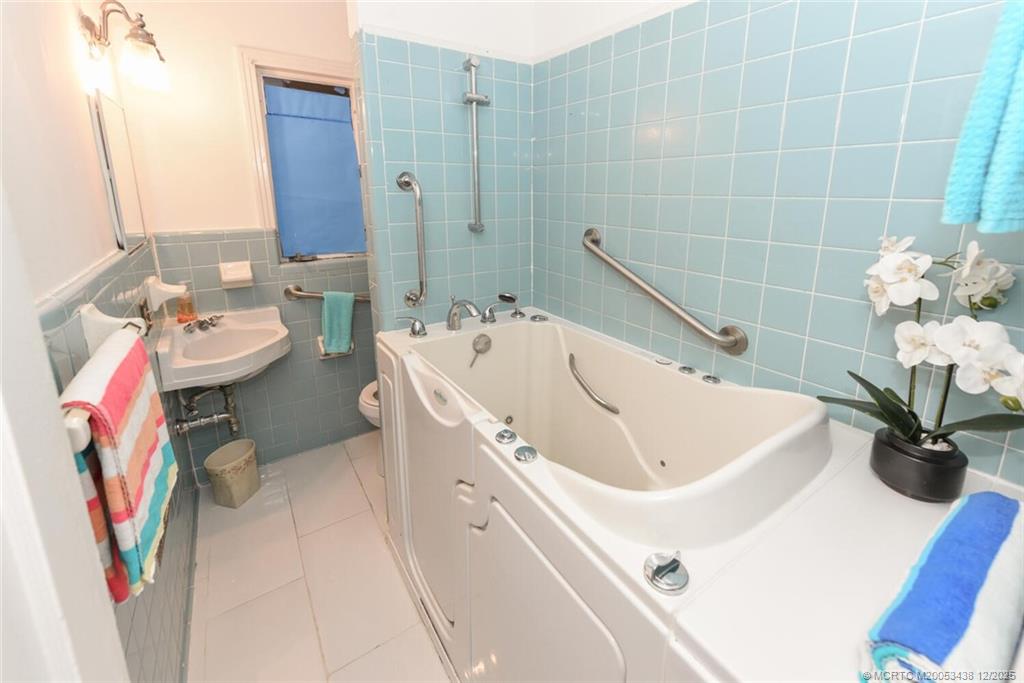 817 Southwest St Lucie Crescent Stuart, FL 34994 - Photo 11 of 25 a bathroom with a sink a toilet and shower