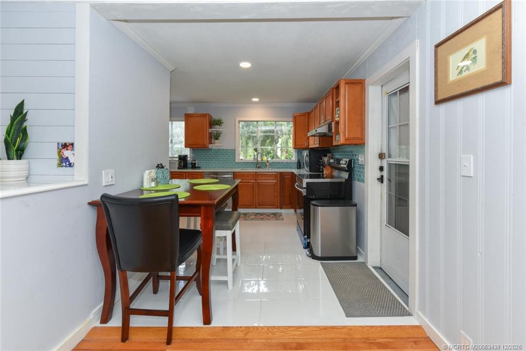817 Southwest St Lucie Crescent Stuart, FL 34994 - Photo 19 of 25 a kitchen with a table chairs refrigerator and microwave