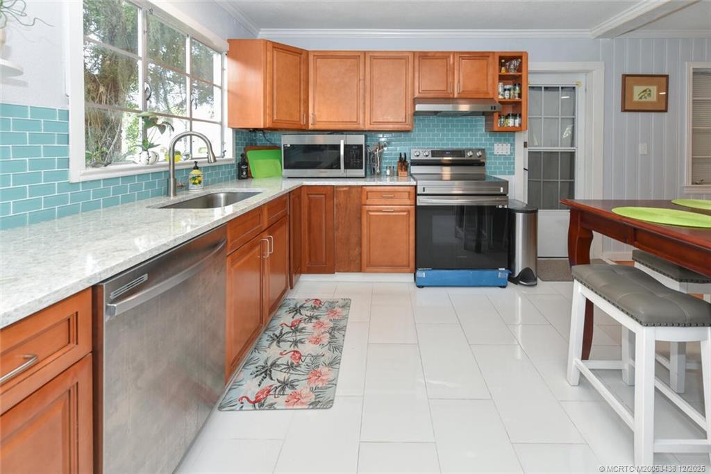 817 Southwest St Lucie Crescent Stuart, FL 34994 - Photo 21 of 25 a kitchen with stainless steel appliances granite countertop a stove a sink and a microwave