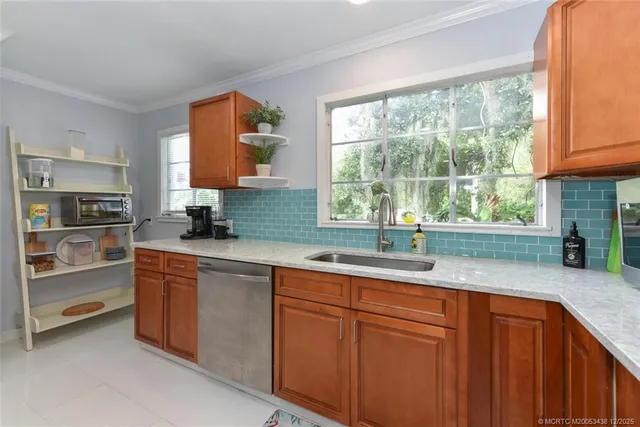 a kitchen with wooden cabinets a sink and a window