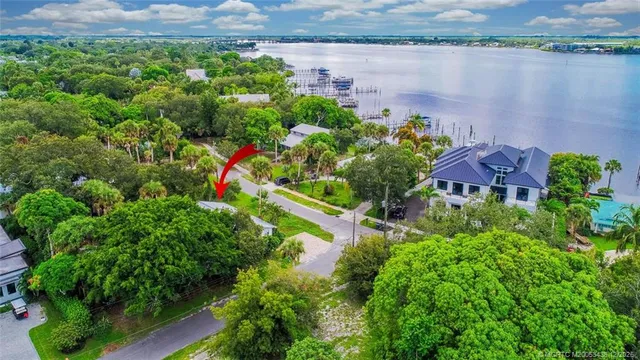 an aerial view of a house with a yard and lake view