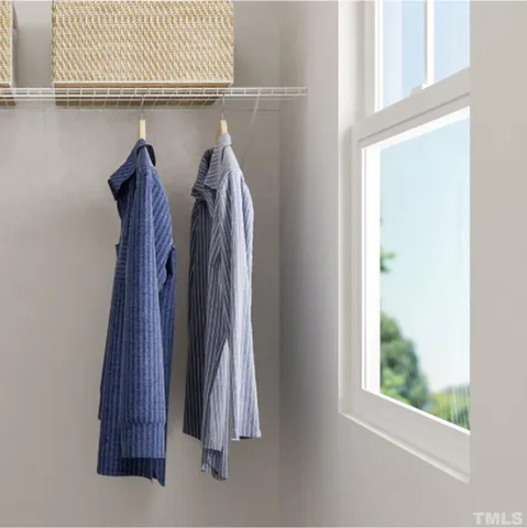 a view of walk in closet with clothes