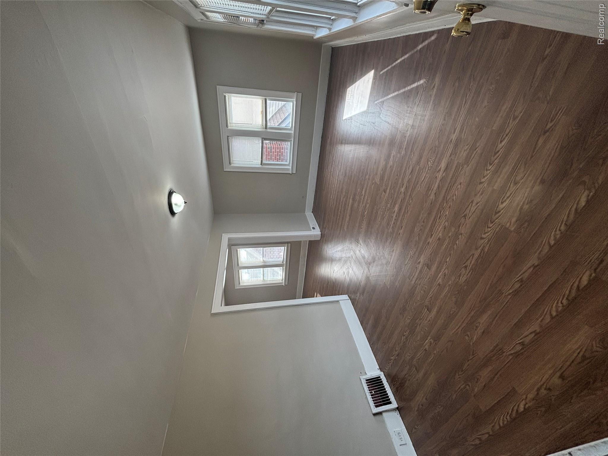 4740-4742 Alter Road Detroit, MI 48215 - Photo 10 of 20 Wood-finish flooring, neutral wall tones, and multiple windows with white trim
