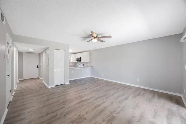 a view of a livingroom with wooden floor and a ceiling fan