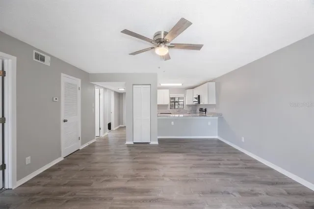 a view of a kitchen with wooden floor and a ceiling fan