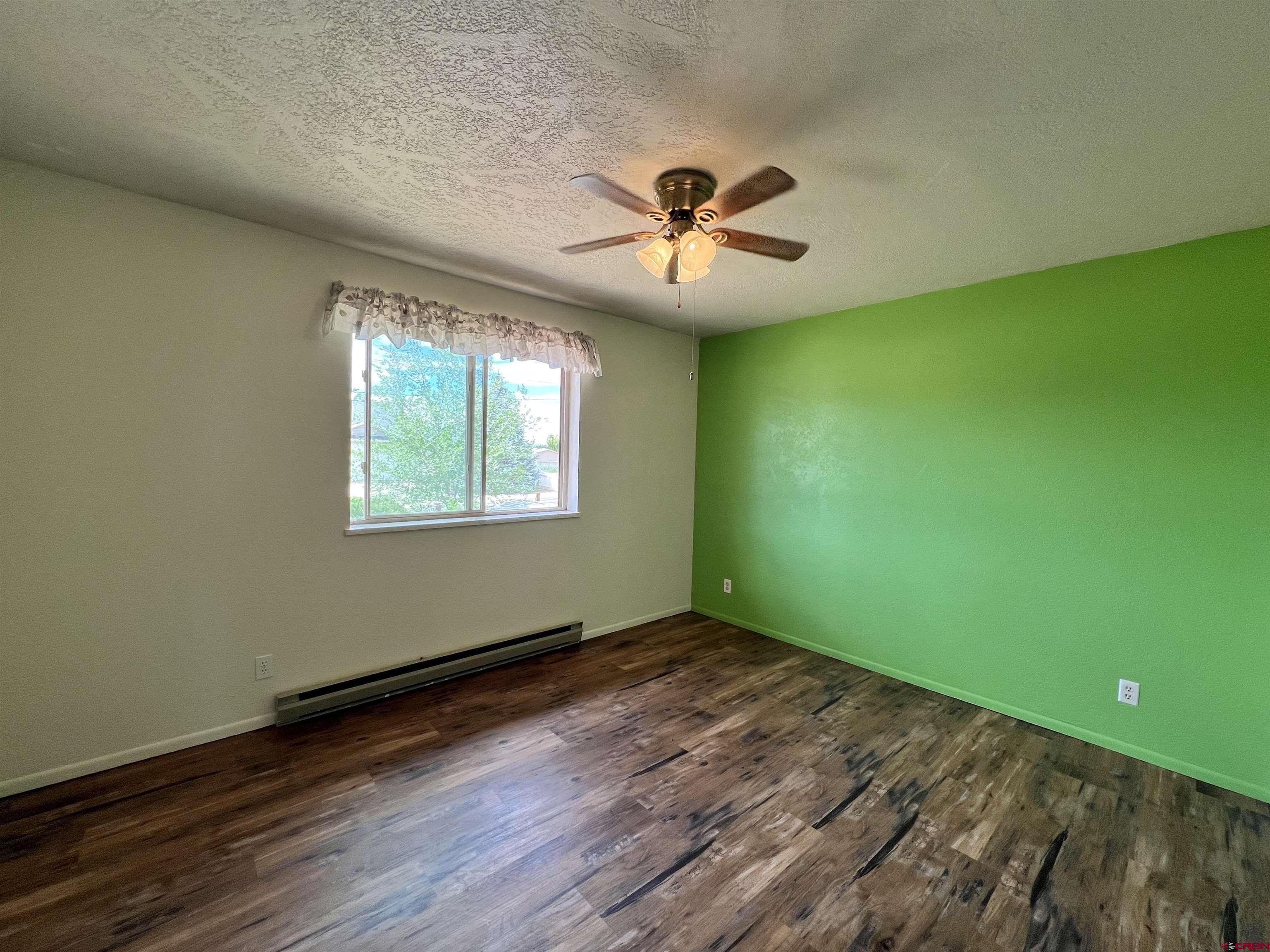 1328 Jackson Street Cortez, CO 81321 - Photo 15 of 37 a view of empty room with wooden floor and fan