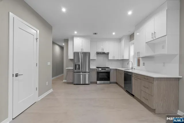 a kitchen with stainless steel appliances a refrigerator sink and stove