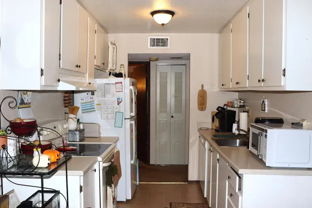 a kitchen with stainless steel appliances granite countertop a refrigerator and a stove top oven