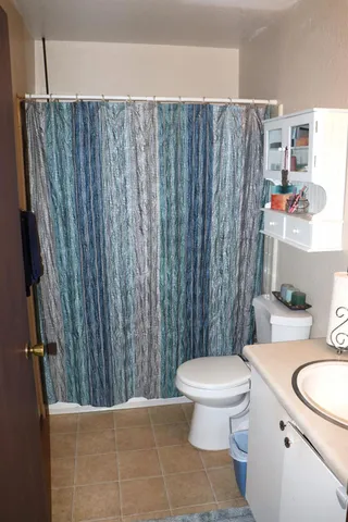 a bathroom with a granite countertop toilet and a sink