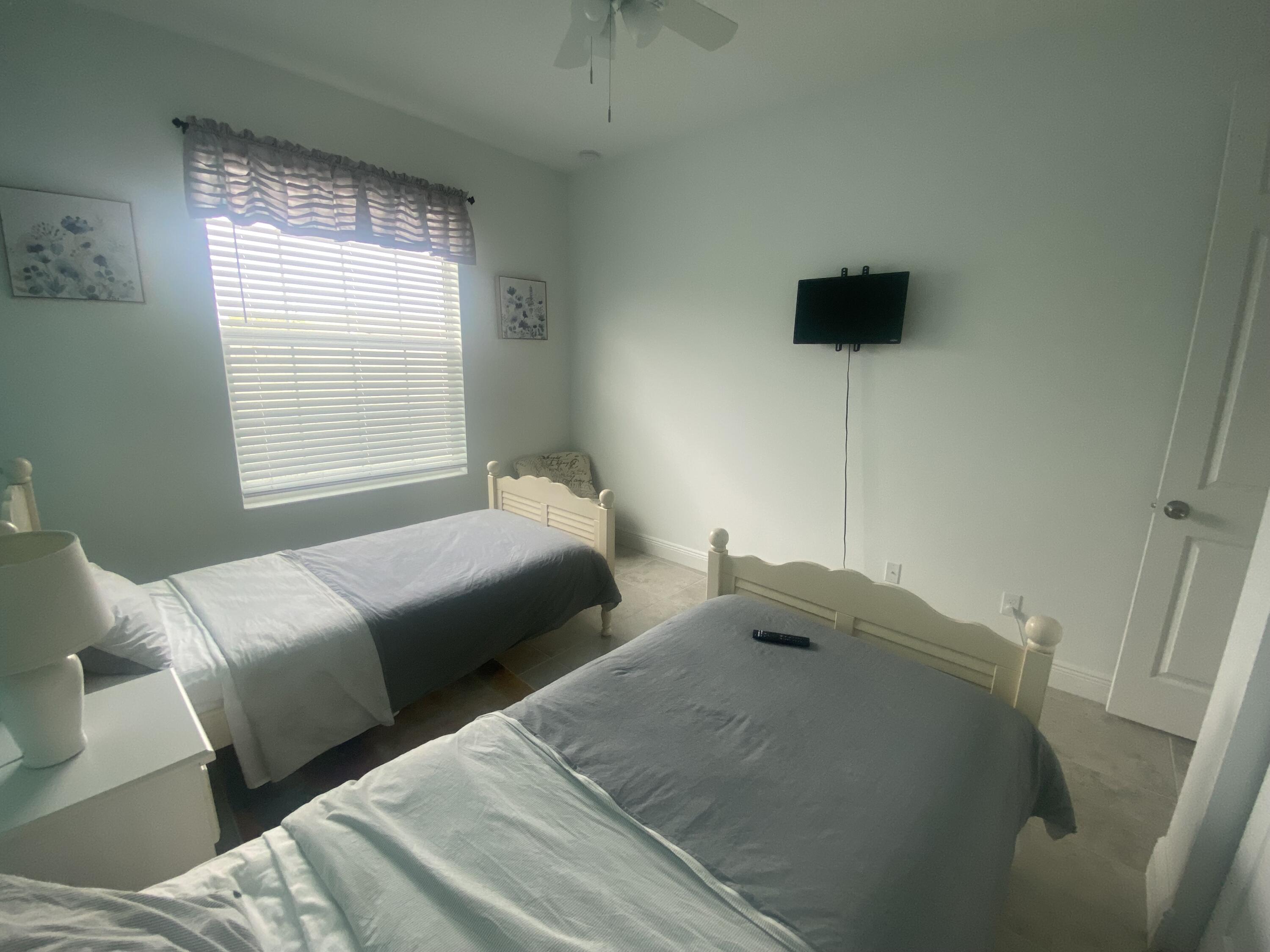 656 Southwest Haas Avenue Port St. Lucie, FL 34953 - Photo 17 of 31 a bedroom with a bed and a flat tv screen