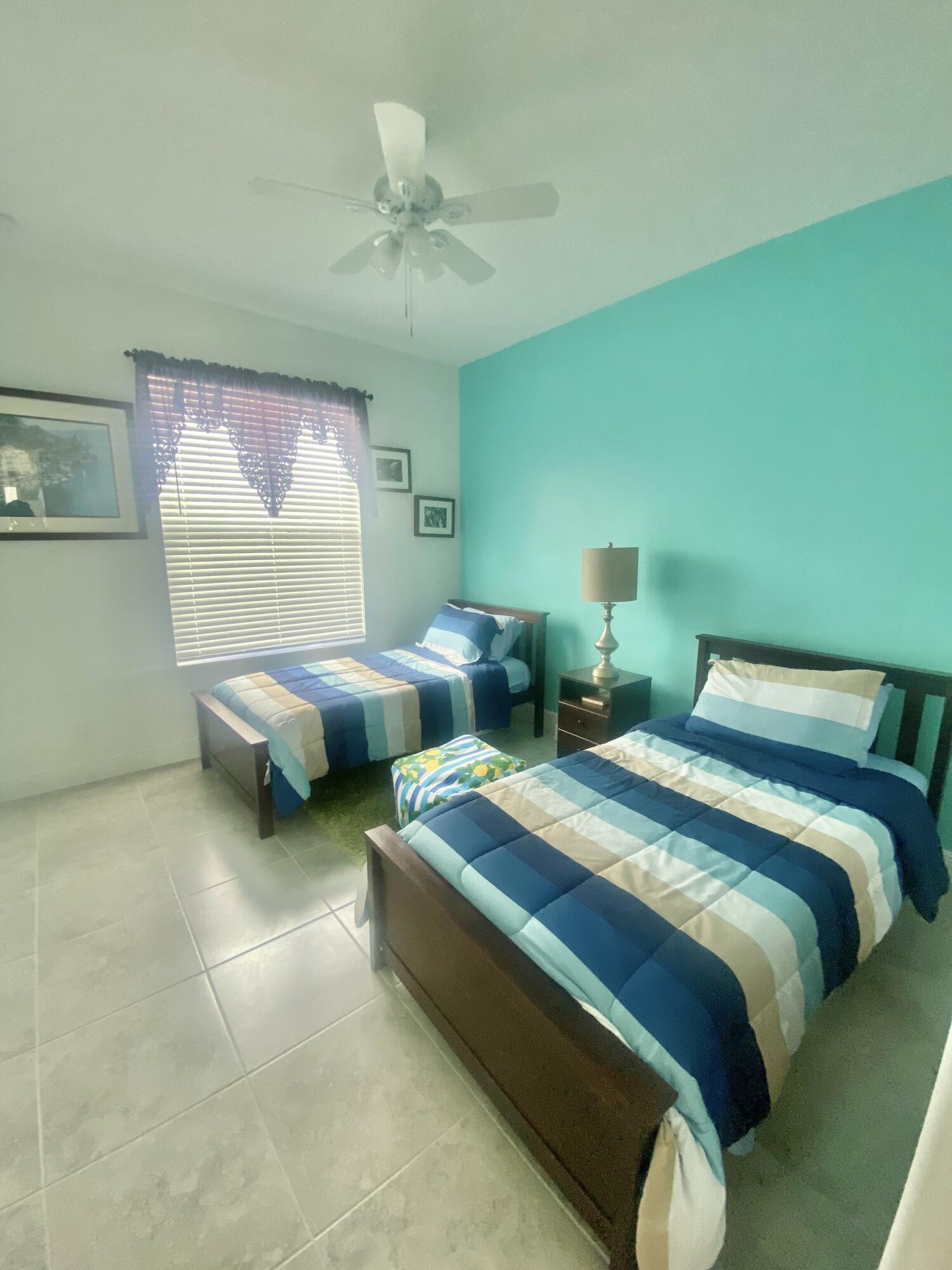 656 Southwest Haas Avenue Port St. Lucie, FL 34953 - Photo 22 of 31 a spacious bedroom with two beds and a chandelier