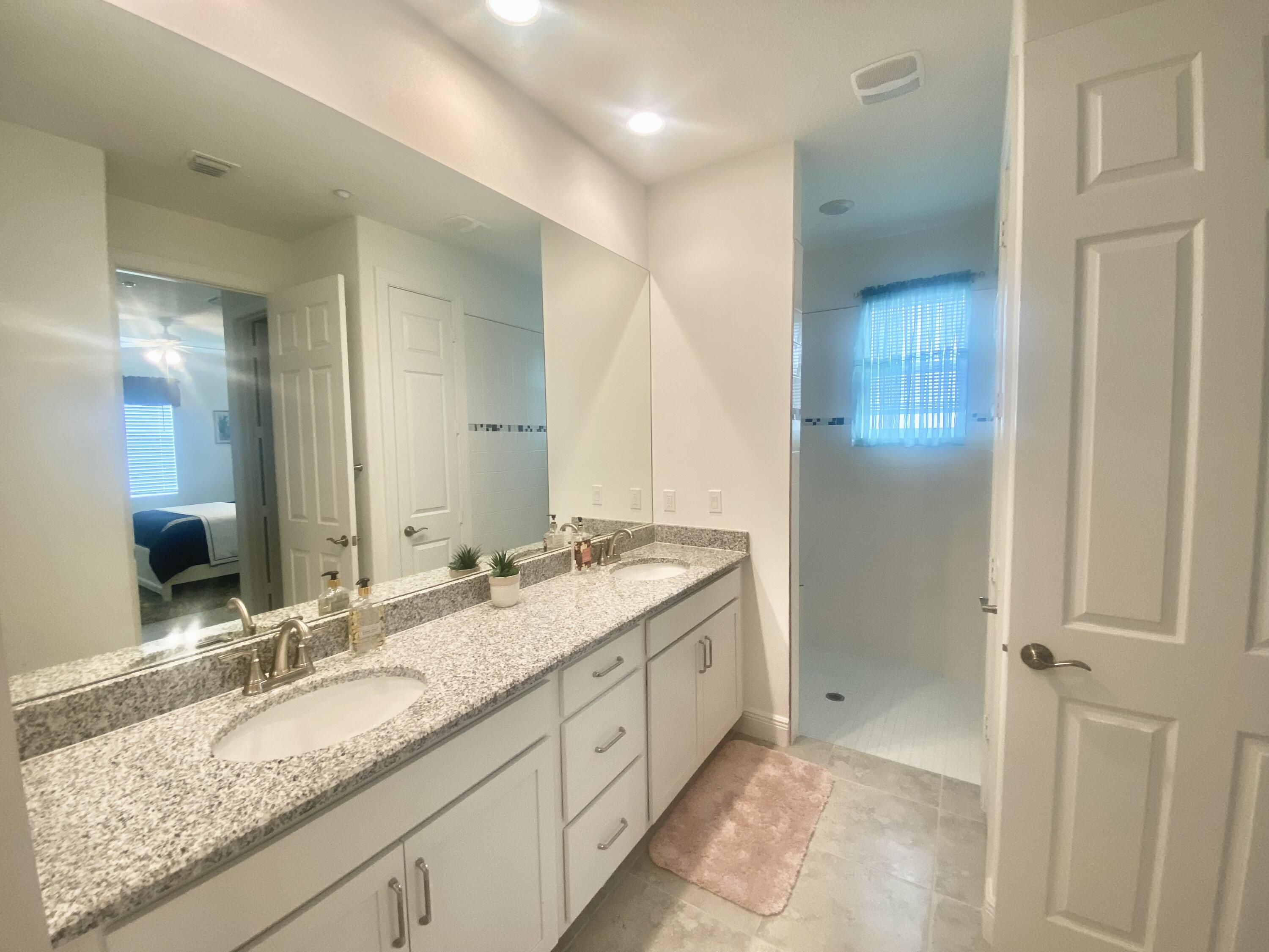 656 Southwest Haas Avenue Port St. Lucie, FL 34953 - Photo 29 of 31 a spacious bathroom with a granite countertop sink and a mirror