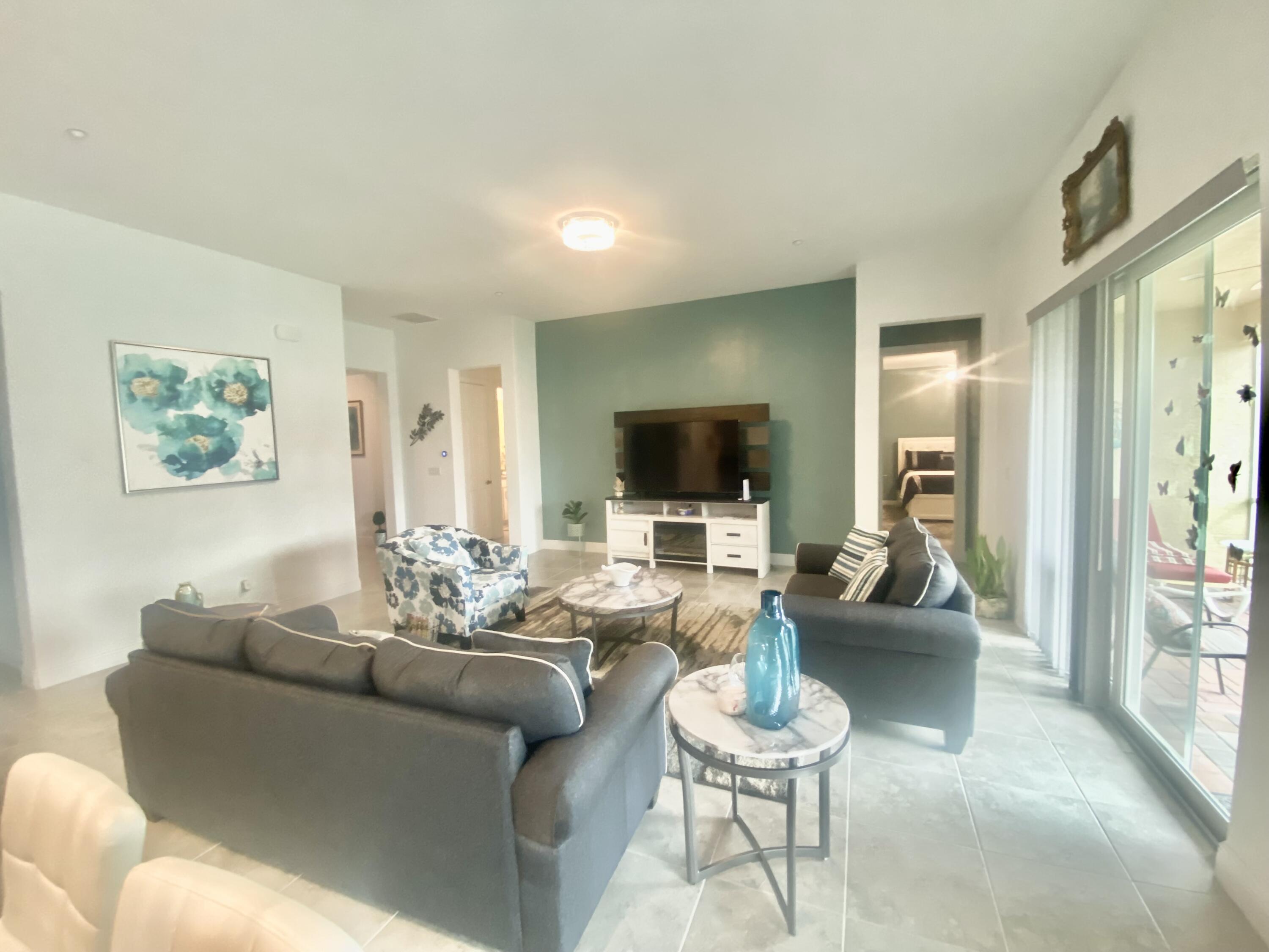 656 Southwest Haas Avenue Port St. Lucie, FL 34953 - Photo 30 of 31 a living room with furniture and a flat screen tv