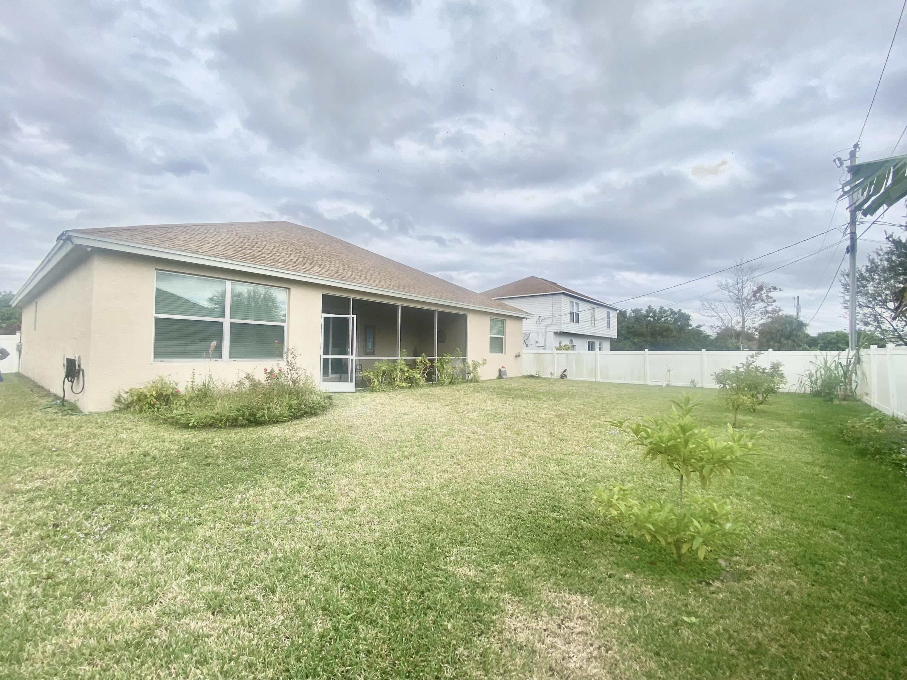 656 Southwest Haas Avenue Port St. Lucie, FL 34953 - Photo 4 of 31 a view of a house with a yard and sitting area