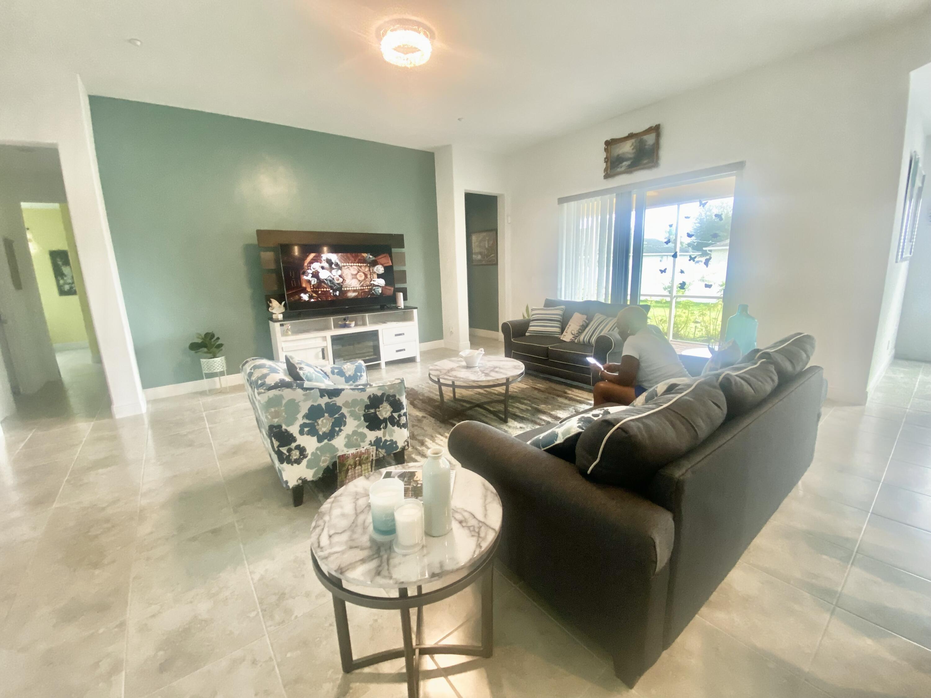 656 Southwest Haas Avenue Port St. Lucie, FL 34953 - Photo 7 of 31 a living room with furniture and a flat screen tv