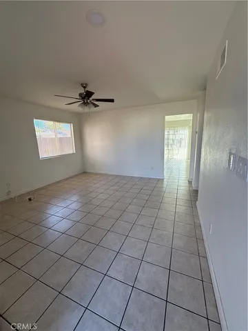 a view of a room with wooden floor and ceiling fan