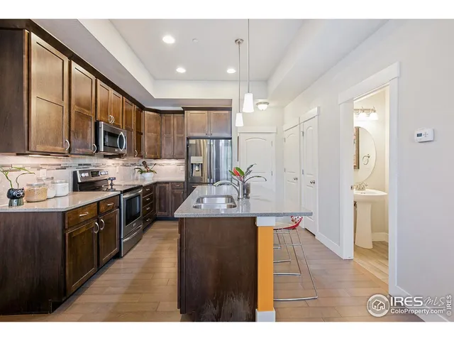 a kitchen with stainless steel appliances granite countertop a sink refrigerator and cabinets