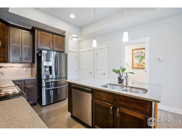 a kitchen with stainless steel appliances kitchen island granite countertop a stove a sink a microwave and a dining table