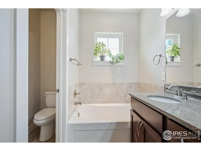 a bathroom with a granite countertop sink a large mirror and a shower